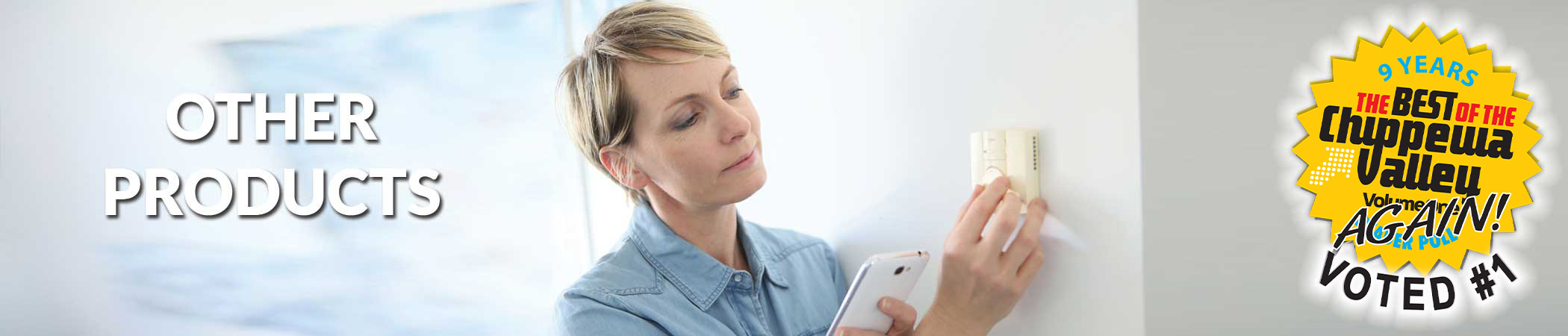 photo of smiling woman sitting on a couch with a remote control in her hand that controls the air-conditioning unit